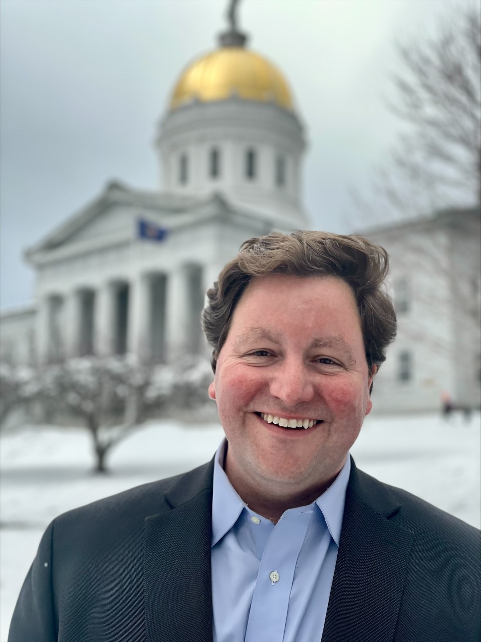 State Treasurer Mike Pieciak standing in front of the Vermont Statehouse